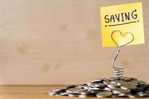 Pile of coins with saving label on a wooden table. Financial Concept. Selective focus. Free space for text photo