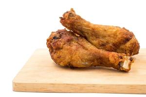 Fried chicken legs on wooden tray over a white background. photo