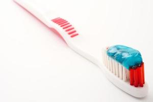 primer plano del cepillo de dientes con pasta de dientes sobre un fondo blanco. foto