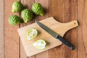 Bergamot or kaffir lime with knife on wooden table background. photo