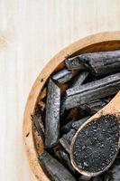 Charcoal and charcoal powder on wooden table background. photo