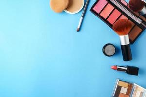 Top view of cosmetics set for makeup on a blue background. Free space for text. photo