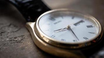 Close up front view of a modern wrist watch on the table. Soft focus photo