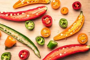 Colorful mix of chili pappers on wooden background. photo