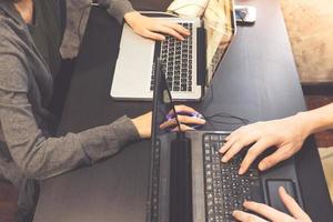 Coworkers working on the same desk, they are using a laptop, Start up business concept, Vintage tone photo