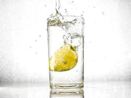 Glass of water with lime on white background. photo