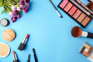 Top view of cosmetics set for makeup on a blue background. Free space for text. photo
