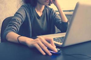 Close up of Casual young woman using a laptop on the desk. Vintage tone photo