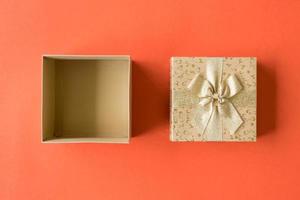 Top view of open gift box on orange background photo