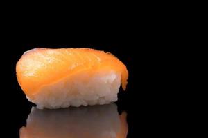 Sushi, japanese food, rice with salmon on black background. photo