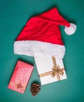 Top view of empty gift boxes with santa hat on green background. photo