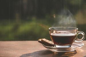 taza de café en la mesa dentro de la ventana, pausa para el café por la mañana con luz solar, conceptos relajantes y refrescantes. foto