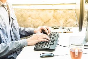 Close up of Male hands typing on desktop computer keyboard in a home office photo