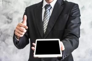Close up of businessman holding tablet device on grunge background. photo