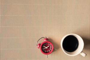 Top view of coffee cup with clock on table. Free space for text photo