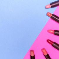 lápices labiales en colores de fondo. concepto de maquillaje y belleza foto