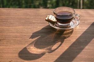 Cup of coffee on the table inside the window, coffee break in the morning with sunlight, relaxing and refreshing concepts. photo