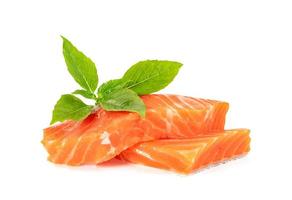 Piece of fresh salmon fillet sliced with leaf basil isolated on white background photo