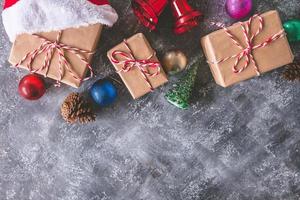 vista superior de paquetes de regalo envueltos en papel marrón con decoración navideña sobre fondo gris grunge. espacio libre para texto