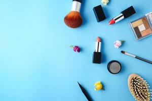 Top view of cosmetics set for makeup on a blue background. Free space for text. photo