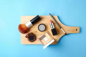 Top view of cosmetics set for makeup on a blue background. Free space for text. photo