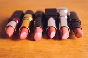 Colorful lipsticks on the wooden table. Makeup and Beauty concept. photo