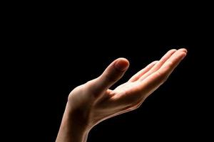 Male hand on a black background. photo