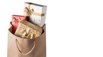 Gift boxes in brown paper bag on white background. Free space for text photo