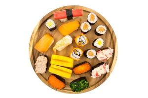 Top view of Sushi set on wooden plate on white background, Japanese food. photo