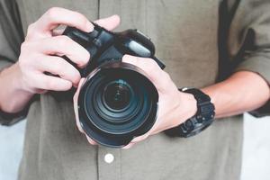 el primer plano de un hombre casual sostiene una cámara, concepto de fotografía. foto