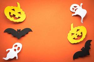 Halloween holiday background with pumpkins, ghosts and bats cut paper on orange background. Free space for text. photo