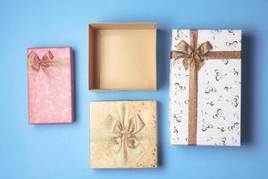 Top view of open gift box and presents on blue background. photo