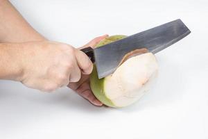 hand holding knife with coconut peeling on white background photo