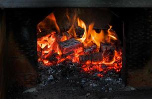 Crest of flame on burning wood in fireplace. Burning firewood in a Russian stove. photo