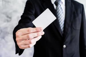 Close up of businessman holding white blank card on grunge background. photo