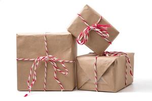 Gift packages wrapped in brown paper on white background. photo