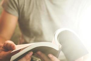 Close up of male hands holding a book to read, Flare from the sunlight photo