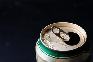 Close up of opened beer can on a black background. photo