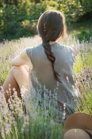 la chica se sienta en medio de un campo de lavanda foto