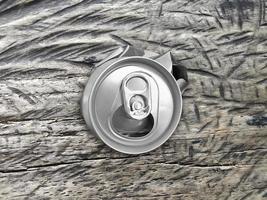 Soda crushed junk can on vintage wood texture background, top view photo