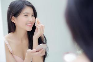 Closeup hand of young asian woman holding product cosmetic applying cream in jar, beautiful girl hand touch lotion for rejuvenation, beauty perfect, treatment and skin care and health concept. photo