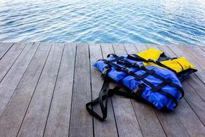 life jacket on wooden floor for product placementwith natural pattern texture. photo