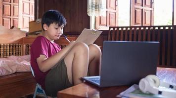 los niños asiáticos disfrutan del tiempo libre practicando el dibujo a lápiz en casa durante las vacaciones escolares. concepto de creadores de niños foto