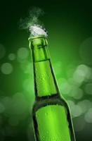 Cold wet open beer bottle with smoke on green bokeh background. 3d render photo