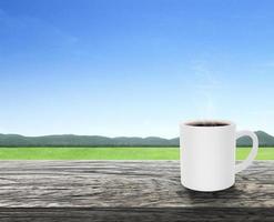 taza de café con humo en la terraza de la mesa de madera con un ambiente refrescante por la mañana, paisaje natural foto