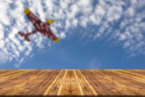 Wooden table with blur sky and plane background photo