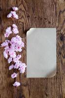 brown paper and pink flowers on wooden background photo