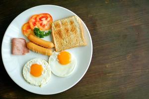 Top view of American breakfast on dark brown wooden table. photo