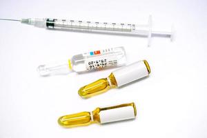 3 ml. brown Ampules of drug and plastic syringe on white background. photo