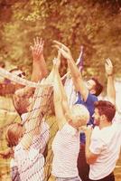 group of young friends playing Beach volleyball photo